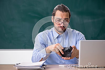 Young underpaid male teacher in the classroom Stock Photo