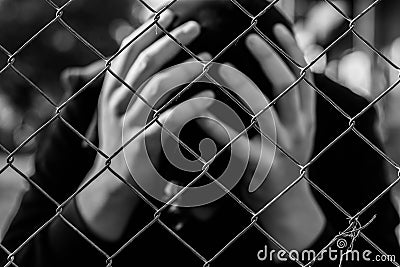 Young unidentifiable teenage boy holding hes head at the correctional institute Stock Photo