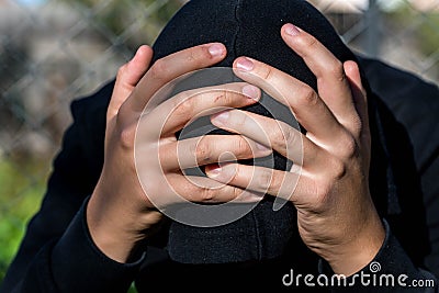 Young unidentifiable teenage boy holding hes head at the correctional institute Stock Photo