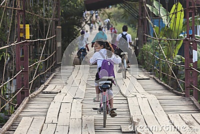 Young unidentified girl cycling back from school Editorial Stock Photo