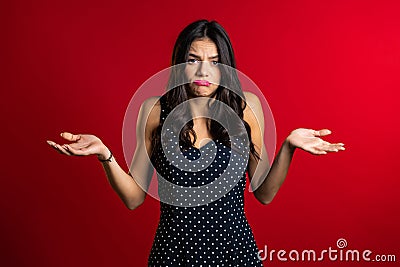 Young unsure girl shrugs her arms, makes gesture of I don`t know, care Stock Photo