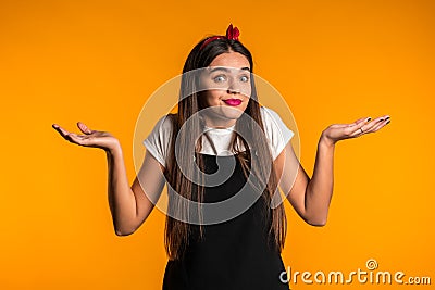 Young unsure girl shrugs her arms, makes gesture of I don`t know, care Stock Photo