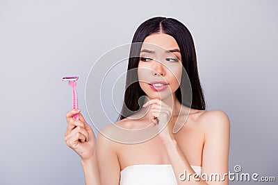 Young unsure nervous asian girl with pink shaver is standing iso Stock Photo