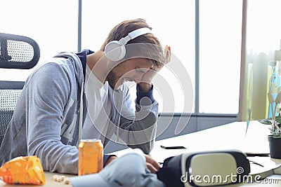 Young upset gamer playing online video games on computer and feel depressed Stock Photo
