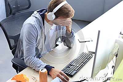 Young upset gamer playing online video games on computer and feel depressed Stock Photo