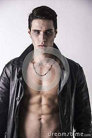 Young Vampire Man in an Open Black Leather Jacket, Showing his Chest and Abs Stock Photo