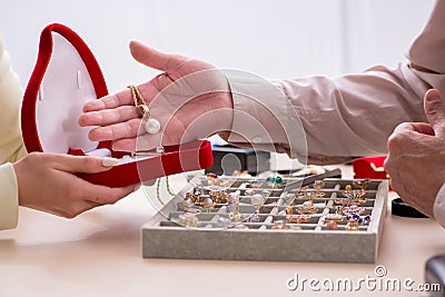 Young woman visiting old male jeweler Stock Photo