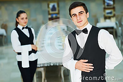 Young waiter and waitress at service in restaurant Stock Photo