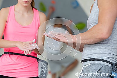 Young wall climbing couple putting chalk on hands Stock Photo