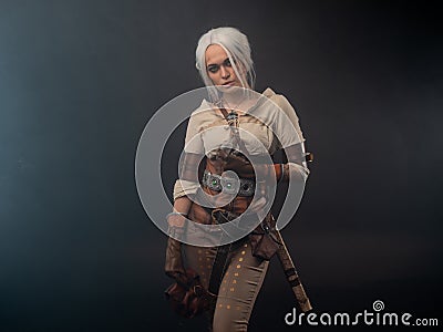 A young warrior with a sword on a dark background. Stock Photo