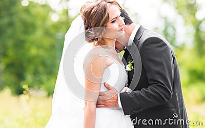 Young wedding couple enjoying romantic moments outside on a summer meadow Stock Photo