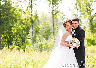 Young wedding couple enjoying romantic moments outside on a summer meadow Stock Photo