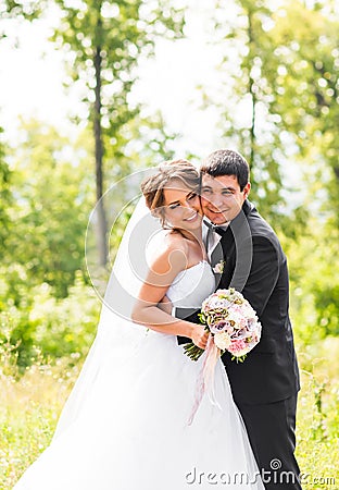 Young wedding couple enjoying romantic moments outside on a summer meadow Stock Photo