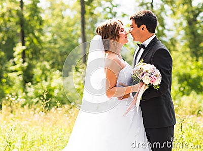 Young wedding couple enjoying romantic moments outside on a summer meadow Stock Photo