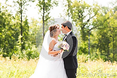 Young wedding couple enjoying romantic moments outside on a summer meadow Stock Photo
