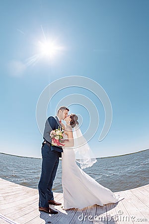 https://thumbs.dreamstime.com/x/young-wedding-couple-kissing-pier-bride-groom-against-sunshine-beautiful-romantic-married-70283134.jpg