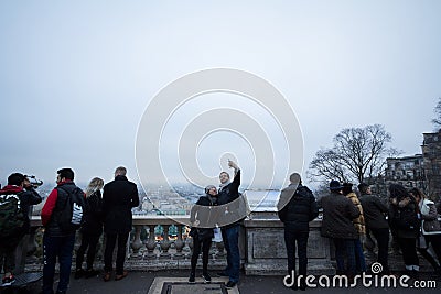 Young white couple taking a selfie in he middle of a tourist crowd on the Montmartre hill Editorial Stock Photo