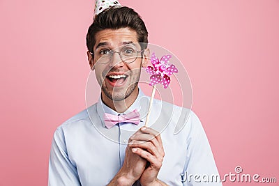 Young white man wearing party cone posing with flower wind spinner Stock Photo