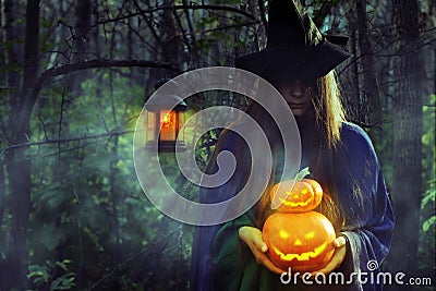 Young witch in the dark forest on Halloween. Stock Photo