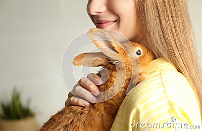 Young woman with adorable rabbit, closeup. Lovely pet Stock Photo