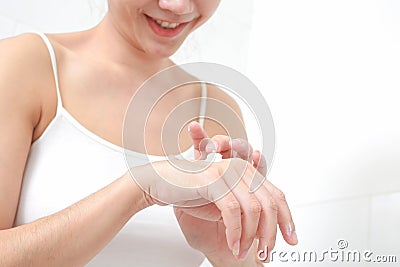 Young woman applies cream on her hands. Stock Photo