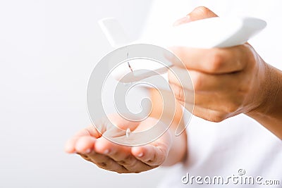 Young woman applying drop dispenser sanitizer alcohol gel on hand Stock Photo