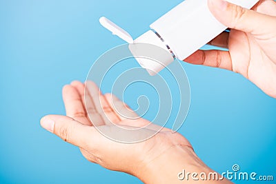 Young woman applying drop dispenser sanitizer alcohol gel on hand Stock Photo