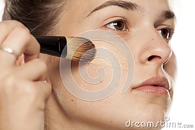 Woman applying foundation Stock Photo