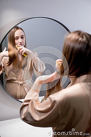 Young woman applying natural organic essential oil on hair and skin. Home spa and beauty rituals. Skin care Stock Photo