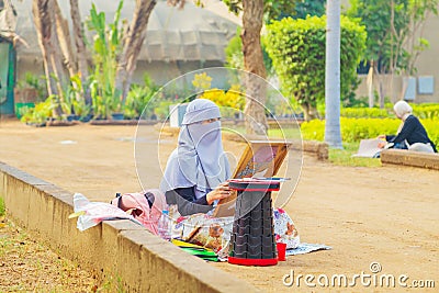 A young woman artist paints plein air in a city park Editorial Stock Photo