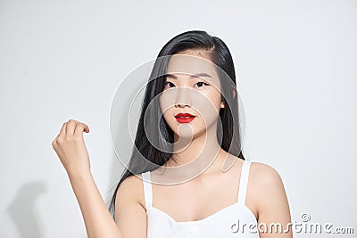 Young woman Asian appearance with black hair stands isolated white background in Studio Stock Photo