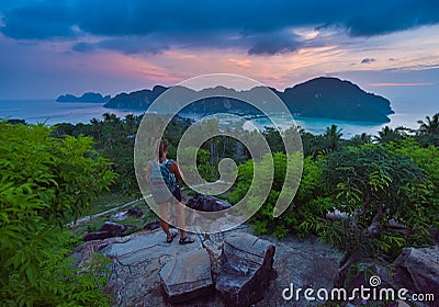 Female Backpacker admires beautiful landscape of the Ko Phi Phi after sunset, Thailand Stock Photo