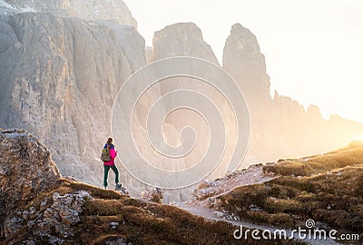 Young woman with backpack on the mountain trail and mountain Stock Photo