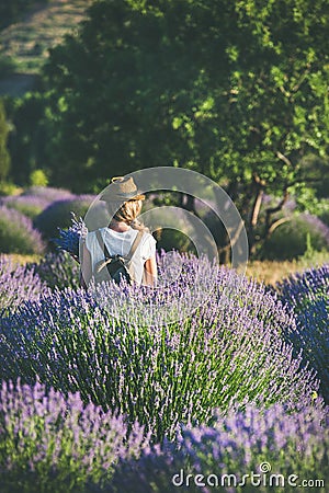 Young woman with backpack standing in lavender field, Isparta, Turkey Stock Photo