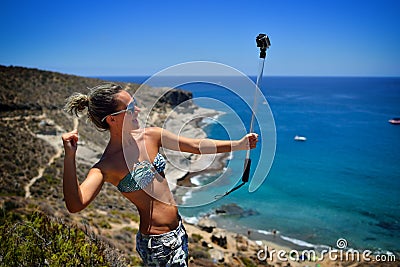 Young woman on the beach in summer using gopro Stock Photo