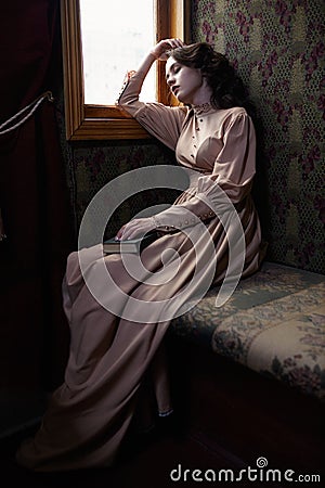 Young woman in beige vintage dress of early 20th century sleapin Stock Photo