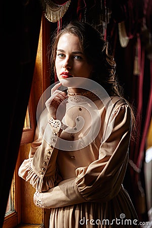 Young woman in beige vintage dress of early 20th century standin Stock Photo