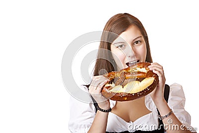 Young woman bites in Oktoberfest Pretzel Stock Photo