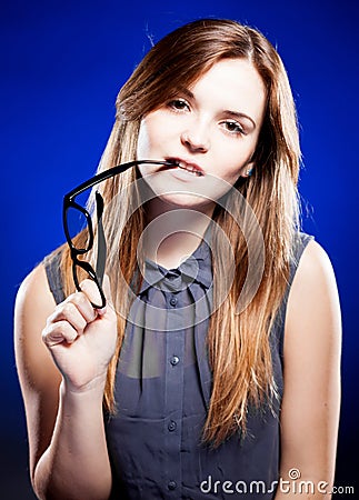 Young woman biting a nerd glasses with interested look Stock Photo