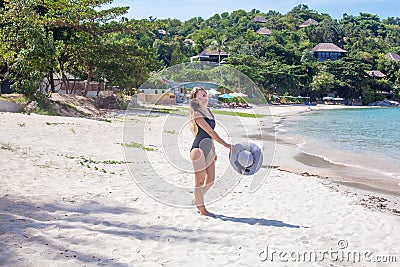 Young woman in black swimsuit on the beach Stock Photo