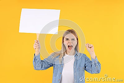 Young woman with blank protest sign on yellow background Stock Photo
