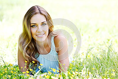 Young woman in blue dress lying on grass Stock Photo