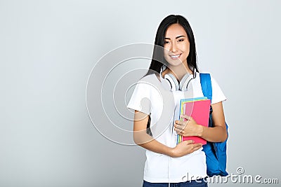 Young woman with books, headphones Stock Photo
