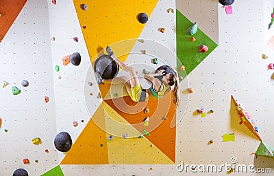 Young woman bouldering in indoor climbing gym Stock Photo