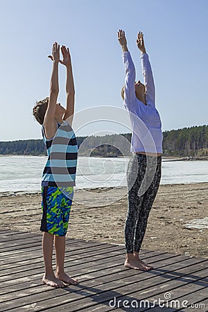 Young woman and boy stretching hands to the sky Stock Photo