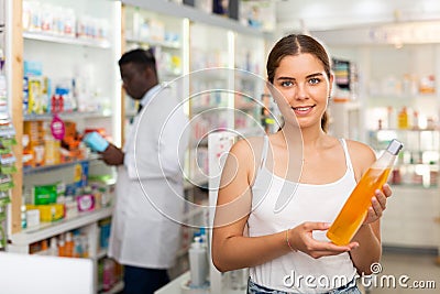 Young woman electing haircare shampoo Stock Photo