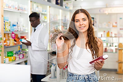 Young woman electing haircare shampoo Stock Photo