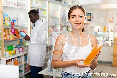 Young woman electing haircare shampoo Stock Photo