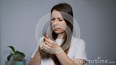Young woman brushes her hair with a comb. Female is doing and styling her hair. Stock Photo