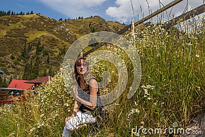 Young woman in camomile field in mountains, Shymbulak, Almaty, K Editorial Stock Photo